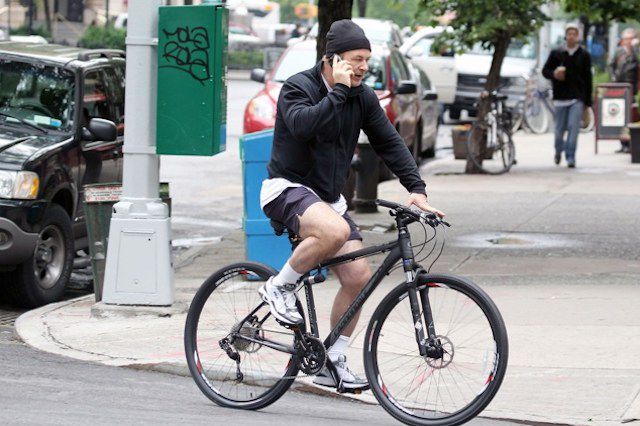 Alec Baldwin, riding his bike and on the cellphone in 2012